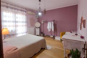 Schlafzimmer mit einem Bett, einem Tisch und einem Spiegel in der Unterkunft MAISON MI.RI' in Termoli