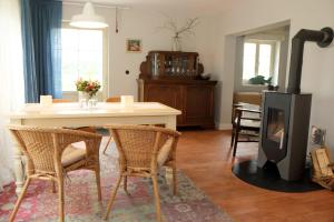 sala de estar con chimenea, mesa y sillas en Cottage, en Buchholz