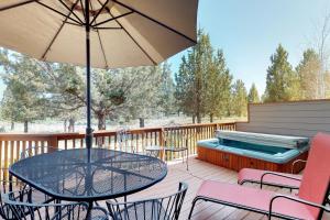 eine Terrasse mit einem Tisch und Stühlen sowie einem Pool in der Unterkunft Happy Goose at Eagle Crest in Redmond