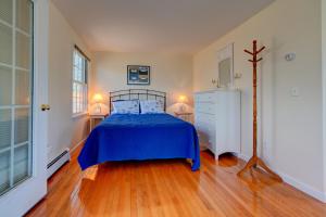 um quarto com uma cama azul e uma cómoda em Treetop em Edgartown