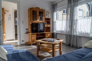 ein Wohnzimmer mit einem TV und einem Tisch in der Unterkunft Ferienwohnungen Scheid Volker in Sankt Aldegund