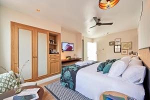 a bedroom with a white bed and a tv at MHOUSE Boutique Hotel Palma in Palma de Mallorca