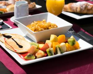 a plate of food with a bowl of food and fruit at The Purple Hotel - Adults Only in San Antonio