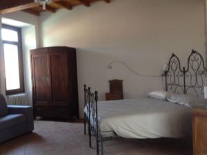 ein Schlafzimmer mit einem Bett, einem Stuhl und einem Sofa in der Unterkunft Casa Clerici - Cà del merican in Nonio