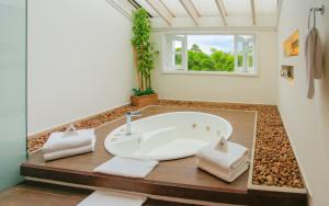 a bathroom with a white tub and a window at Hotel Boutique El Triángulo in Armenia