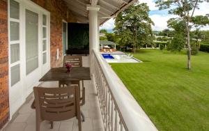 a porch with a table and chairs and a yard at Hotel Boutique El Triángulo in Armenia