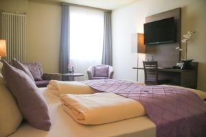 a hotel room with a bed and a tv at Boutique Hotel zur Post in Vohburg an der Donau