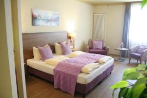 a hotel room with a bed and two chairs at Boutique Hotel zur Post in Vohburg an der Donau