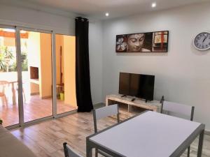 アデへにあるApartamento 1 dormitorio planta baja Costa Adejeのリビングルーム(テーブル、薄型テレビ付)