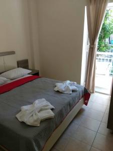 a bedroom with a bed with towels on it at SimOtel Ermis in Hanioti