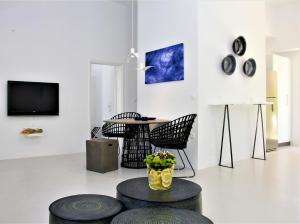 a living room with a table and chairs and a tv at 30villa Rd in Rhodes Town