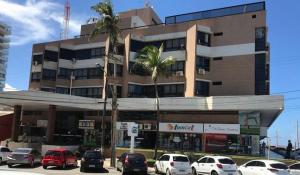 a large building with cars parked in front of it at Flat no Pituba Sol 302 E 311 in Salvador