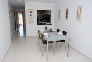 a dining room with a glass table and chairs at Apartamento Montroig 3 Ático in Sitges