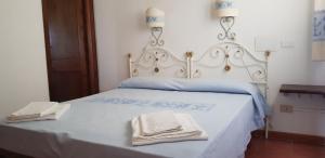 a white bed with two towels on top of it at Residence Spiaggia Bianca in Golfo Aranci