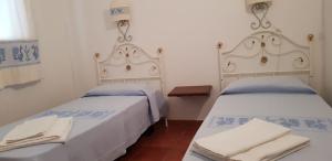 two beds sitting next to each other in a room at Residence Spiaggia Bianca in Golfo Aranci