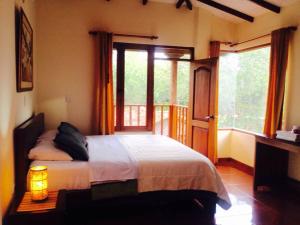 a bedroom with a bed and a large window at Hosteria Campestre San Fermin in Ráquira