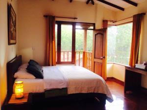 ein Schlafzimmer mit einem Bett und einem großen Fenster in der Unterkunft Hosteria Campestre San Fermin in Ráquira
