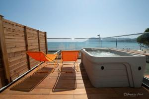 two chairs and a bath tub on a deck at Hôtel George Sand in La Seyne-sur-Mer