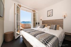a bedroom with a large bed and a balcony at Hôtel George Sand in La Seyne-sur-Mer