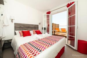 a bedroom with a large bed with red and orange pillows at Hôtel George Sand in La Seyne-sur-Mer