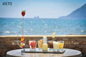 a tray of drinks on a table near the ocean at Hôtel George Sand in La Seyne-sur-Mer