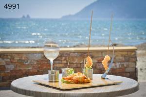 a table with a glass of wine and some food at Hôtel George Sand in La Seyne-sur-Mer