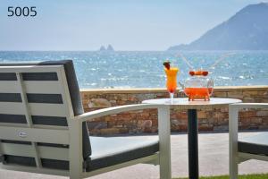 a table with two drinks on it next to a chair at Hôtel George Sand in La Seyne-sur-Mer