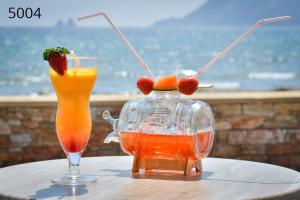 a pitcher of orange juice and a drink on a table at Hôtel George Sand in La Seyne-sur-Mer