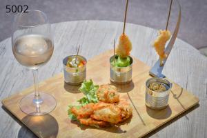 a table with a plate of food and a glass of wine at Hôtel George Sand in La Seyne-sur-Mer