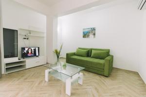 a living room with a green couch and a tv at Miami apartments in Ulcinj