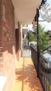 une terrasse couverte d'une maison avec un mur en briques dans l'établissement Apartamentos Atlas Terrassa III, à Terrassa