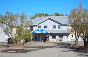 un gran edificio blanco con un cartel que dice "posada de viajes" en Travel-Inn Resort & Campground en Saskatoon