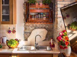 a kitchen with a sink and a counter with flowers at Apartments Roža in Roč