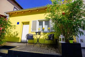 una casa amarilla con una mesa y sillas frente a ella en Apartment 63 - 1, en Zagreb