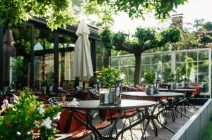 an outdoor patio with tables and chairs and an umbrella at Hotel 't Paviljoen in Rhenen