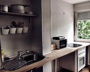 a kitchen with a sink and a microwave at Hostal Ciempozuelos in Ciempozuelos