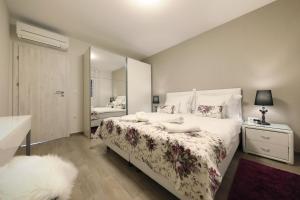 ein Schlafzimmer mit einem großen Bett und einem Spiegel in der Unterkunft Luxury Majpruz Suites in Zadar