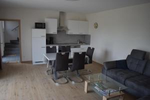 sala de estar con sofá, mesa y sillas en Ferienwohnung Kerstenhof, en Willich