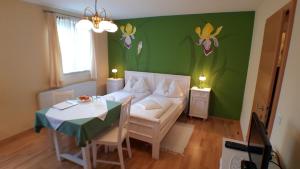 a room with a bed and a table and a table and a room with at Pension Arkadenhof in Premstätten