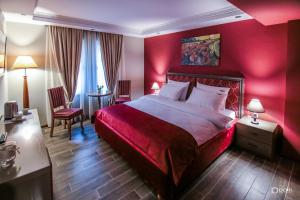 ein rotes Schlafzimmer mit einem Bett, einem Tisch und Stühlen in der Unterkunft Hotel Restaurant Vila Ime Voskopoje in Voskopoja