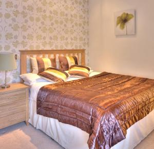a bedroom with a large bed and a night stand at The Carlton in Rugby