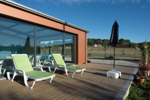 una terraza con sillas y una sombrilla. en Casas de Sequeiros, en Sequeiros