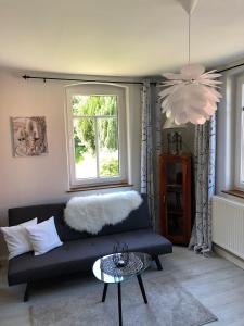 a living room with a black couch and a window at Fuchsbau in Königstein an der Elbe