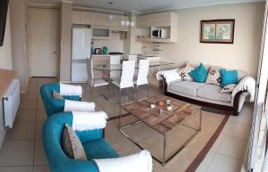 Una sala de estar con dos sofás y una mesa. en Laguna Playa Privada, Vista al Mar, en Algarrobo