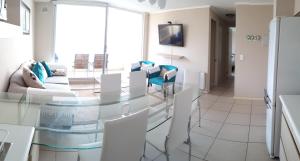 Un comedor con una mesa de cristal y sillas blancas. en Laguna Playa Privada, Vista al Mar, en Algarrobo 28 fotos más