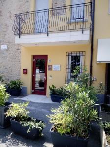ロナートにあるI Colli del Gardaの赤い扉と鉢植えの建物