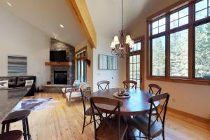 a dining room and living room with a table and chairs at Alpenglow 37C in Big Sky
