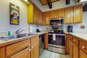 a kitchen with wooden cabinets and stainless steel appliances at Timber Creek in Copper Mountain