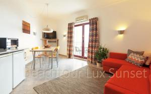 a living room with a red couch and a table at T2 Apt-Beachtour Lux Sunset - Ericeira in Ericeira