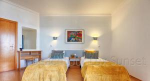 a hotel room with two beds and a table at T2 Apt-Beachtour Lux Sunset - Ericeira in Ericeira +17 photos